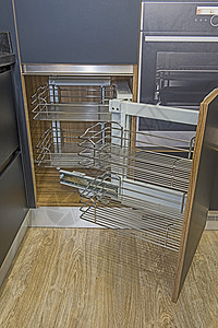 在一个豪华公寓的现代厨房角落橱柜设计旋转木马家具贮存奢华木地板搁板木头橱柜门金属架装饰图片
