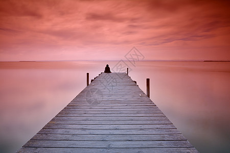 孤独的人坐在码头上图片