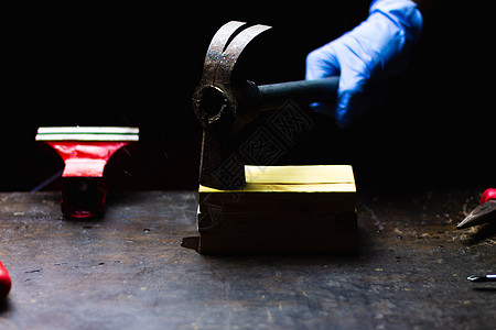 手戴蓝色手套用锤子敲打木箱维修维护和工艺的概念图片