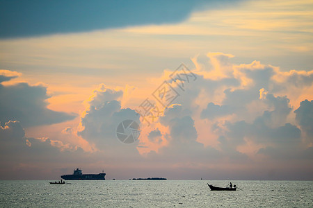 黑月光和渔船上的日落橙色乌云火焰橙子金子太阳海洋云景季节蓝色钓鱼戏剧性图片