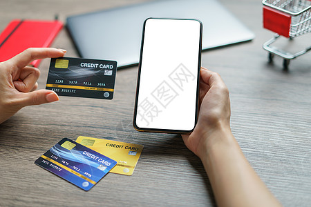 使用智能手机的亲手费和网上电话信用卡费用技术命令顾客卡片笔记微笑互联网借方商业电脑图片