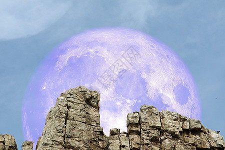 在悬崖的岩石上 飞回石头上的超级月亮图片