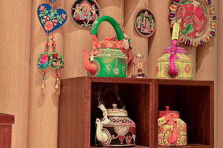在新德里迪利哈特的一家零售店展出彩绘装饰性传统印度水壶 捕梦网和风铃图片