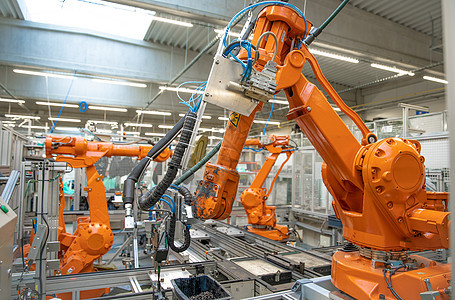 生产线上的橙色机械臂 由具有人工智能的计算机控制图片