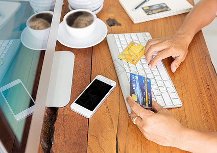使用计算机手持信用卡 用于互联网银行业务和因特网网络电子商务金融电话商业网站信用咖啡店支付购物图片