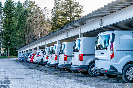 在停车场的一排白色汽车和货车上特写照片 屋顶保护免受阳光和雨雪的影响 针对不同天气条件的安全斯堪的纳维亚运输业务图片