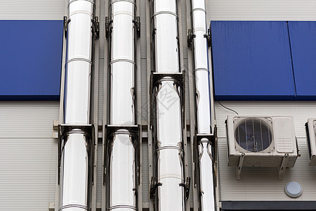 白蓝工业大楼外墙上的镀铬通风管合金烟囱工程技术管子建造建筑学不锈钢金属管道图片