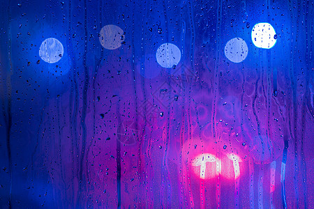红紫色和蓝色夜路灯的抽象背景散景槽湿玻璃与选择性 focu场景圆圈艺术窗户戏剧性玻璃水滴墙纸街道城市图片