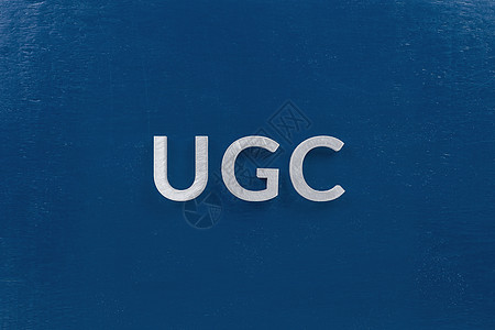 ugc 一词 — 用户生成的内容 — 由白色银色金属字母放置在平坦的 la 经典蓝色背景上图片