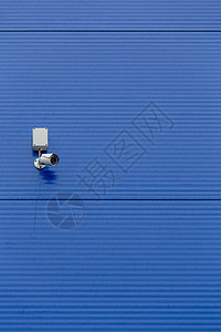 大型蓝色钢筒墙上的小型白色安全摄像头危险建筑隐私镜片警卫电子建造控制板控制金属图片