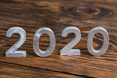 2020 号 深棕色木质背景上有白色金属数字 有选择的焦点物品问候语卡片新年海报假期季节木头庆典邀请函图片