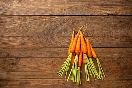 木板和木背景上的新鲜小婴儿胡萝卜绿色蔬菜白色饮食食物营养烹饪橙子植物桌子图片