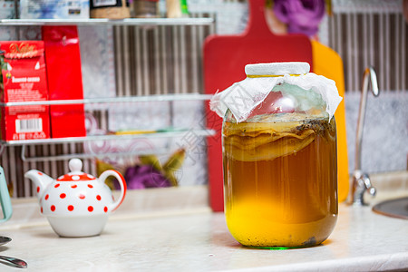 在厨房桌上的玻璃罐里装着自制的Kombucha茶食物药品橙子奶奶文化味道果汁液体饮食活力图片