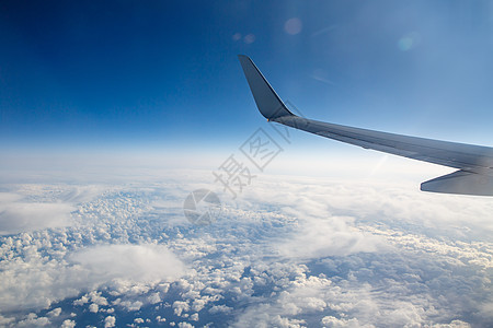 蓝云上方天空中的飞机翼的翅膀地球运输喷射车辆航空阴影旅行天堂引擎晴天图片