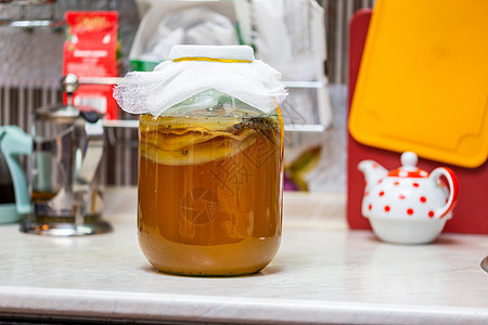 在厨房桌上的玻璃罐里装着自制的Kombucha茶活力药品细菌生活文化饮食桌子味道奶奶橙子图片