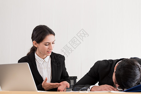 一位女商务人士对同事睡着感到不爽 在W区男人工作员工公司女士文档笔记本商务午睡电脑图片