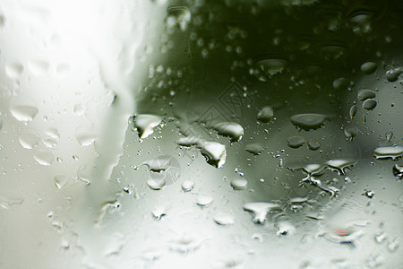 雨滴在挡风玻璃上 背景的夜晚城市灯光模糊不清天气驾驶街道大灯反射蓝色下雨车辆旅行风暴图片