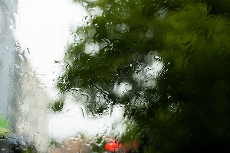 雨天挡风玻璃雨滴在挡风玻璃上 背景的夜晚城市灯光模糊不清反射蓝色驾驶大灯窗户旅行车辆液体运输下雨背景