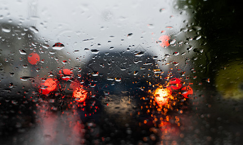 雨滴在挡风玻璃上 背景的夜晚城市灯光模糊不清反射旅行蓝色液体天空大灯天气驾驶车辆风暴图片