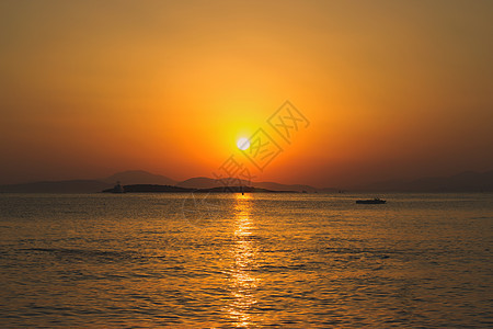 日落在海面上橙子地平线假期天空反射旅行晴天太阳海浪海岸图片