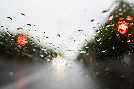 雨滴在挡风玻璃上 背景的夜晚城市灯光模糊不清驾驶液体反射玻璃蓝色旅行交通天空大灯运输图片