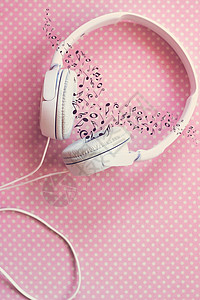 粉红色背景中带音符的白色耳机图片