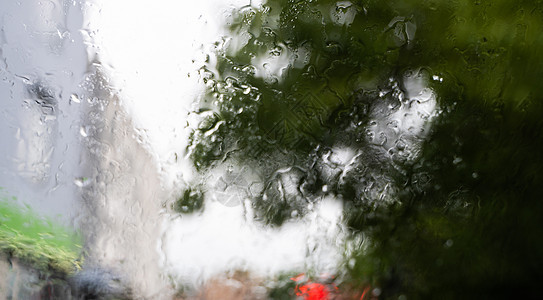 挡风玻璃上闪烁的雨滴 背景是夜间城市灯光天气旅行车辆交通驾驶大灯运输下雨液体窗户图片