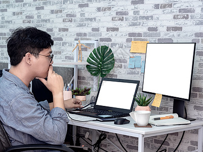 亚洲人在他的房间里用笔记本电脑工作 共有公寓树叶程序员技术男人商业设计师小样远程监视器工人图片