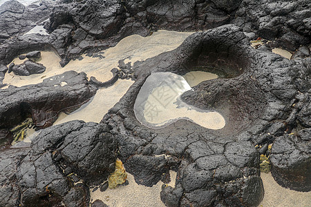 底部有白色沙子的岩石凹陷处充满了海水 在印度洋海岸巴厘岛印度尼西亚的熔岩床中挖掘出的小池塘 潮水在黑色岩石中挖出了小湖海岸线天堂图片