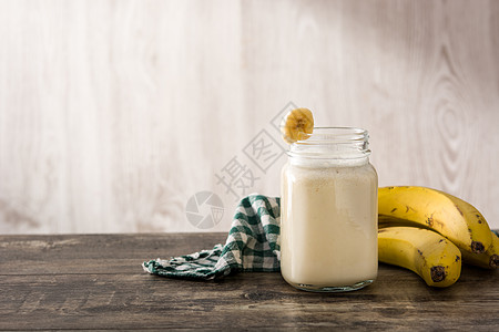 在木制桌子上罐子中的香蕉冰淇淋图片
