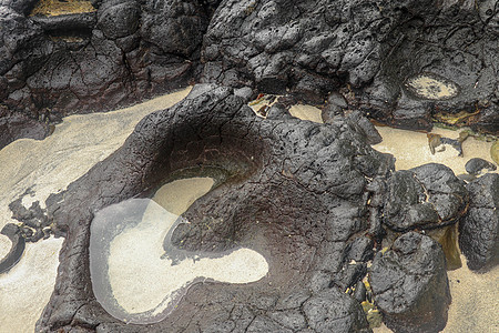 底部有白色沙子的岩石凹陷处充满了海水 在印度洋海岸巴厘岛印度尼西亚的熔岩床中挖掘出的小池塘 潮水在黑色岩石中挖出了小湖孤独反射矿图片