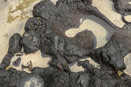 底部有白色沙子的岩石凹陷处充满了海水 在印度洋海岸巴厘岛印度尼西亚的熔岩床中挖掘出的小池塘 潮水在黑色岩石中挖出了小湖沿海热带石图片