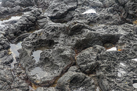 底部有白色沙子的岩石凹陷处充满了海水 在印度洋海岸巴厘岛印度尼西亚的熔岩床中挖掘出的小池塘 潮水在黑色岩石中挖出了小湖海洋海岸线图片