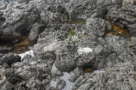 底部有白色沙子的岩石凹陷处充满了海水 在印度洋海岸巴厘岛印度尼西亚的熔岩床中挖掘出的小池塘 潮水在黑色岩石中挖出了小湖海岸线生活图片