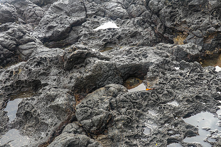 底部有白色沙子的岩石凹陷处充满了海水 在印度洋海岸巴厘岛印度尼西亚的熔岩床中挖掘出的小池塘 潮水在黑色岩石中挖出了小湖海岸线石头图片