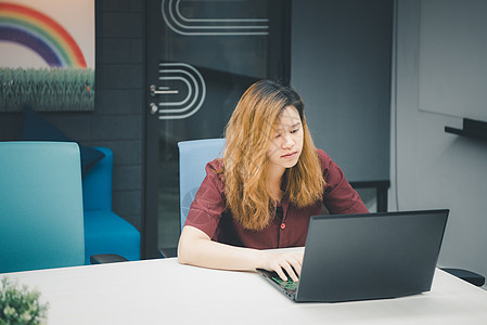 在办公室用笔记本电脑工作的有思想的女性电子商务学习教育桌子技术人士思维互联网学生自由职业者图片