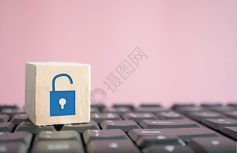 特写解锁图标作为非安全显示在计算机键盘上的木立方体上 保护网络活动业务技术安全密码商业数据犯罪正方形保安按钮笔记本保险封锁图片