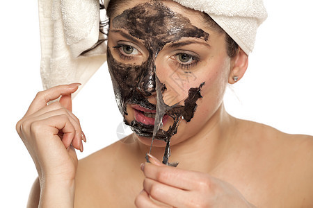 女人脱下她脸上的黑面罩女士净化化妆品黑色产品温泉护理美容毛巾女孩图片