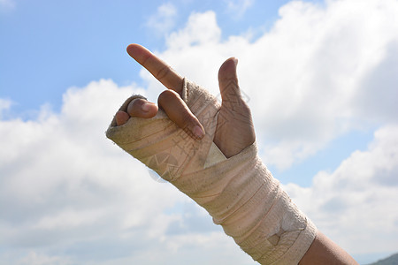 手腕疼痛的人 在巨型板条中 用天空背景的手指锻炼痛苦包扎绷带事故弹力手臂扭伤疾病伤害病人图片
