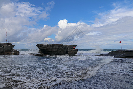 海浪冲击着海神庙的岩石悬崖 海水变成白色泡沫 红色警告旗突出了海洋的危险 肆无忌惮的海洋能源 您的项目的自然背景风险禁令游泳冲浪图片