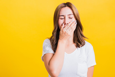 妇女疲倦的情绪 困睡着她紧闭的嘴张着女士女性黑发黄色白色工作室头发女孩困倦青少年图片