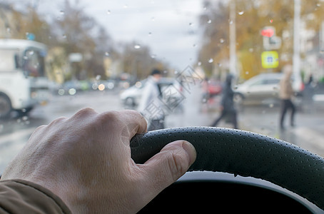 男人的手在汽车方向盘上窗户雨滴车辆城市穿越司机细雨旅行下雨车轮图片