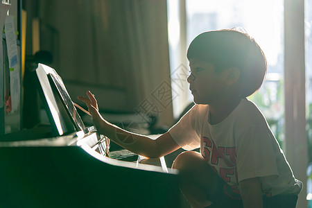 小男孩在家弹钢琴和音乐平板电脑孩子们教育乐器女孩房间钢琴爱好药片旋律男生图片