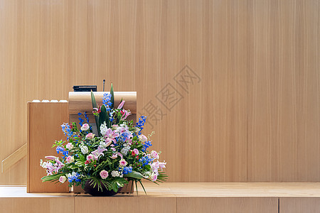在棕色木制舞台的一束花朵上装满了巨大的花束 供讲师 演讲人和演讲人使用图片