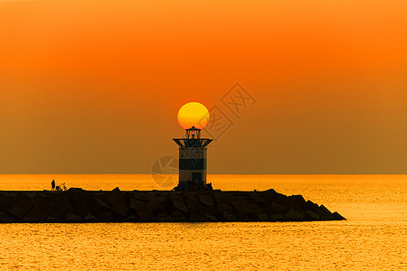 夏日最热的一天 在史芬宁港灯塔上晒日落反射橙子蓝色波浪旅行太阳天空日出红色地平线图片