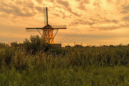 蓝色时分强风吹过野草栅栏之上的荷兰风力车 荷兰阿尔布拉塞尔达姆反射风车建筑地标天空运河环境场地活力小孩图片