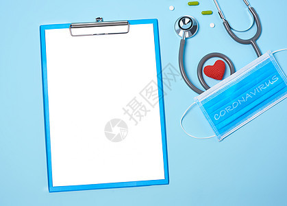医疗设备模拟剪贴板 红色心脏和药物的听诊器 蓝色复制空间背景的外科面具诊断疾病心脏病学诊所药品乐器治疗桌子工具考试图片