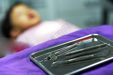 模糊背景的托盘上的牙科工具图片