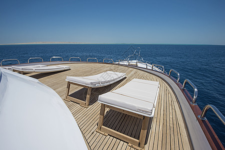 在豪华豪华的游艇上 俯视船首栏杆航海热带航行太阳椅假期娱乐地平线木头闲暇图片