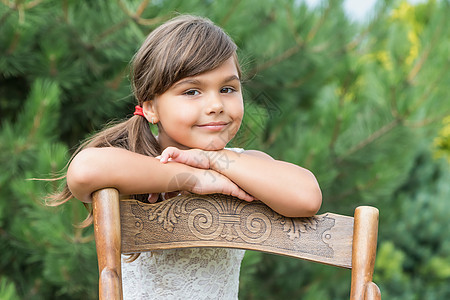 小女孩靠着一把老木椅子图片